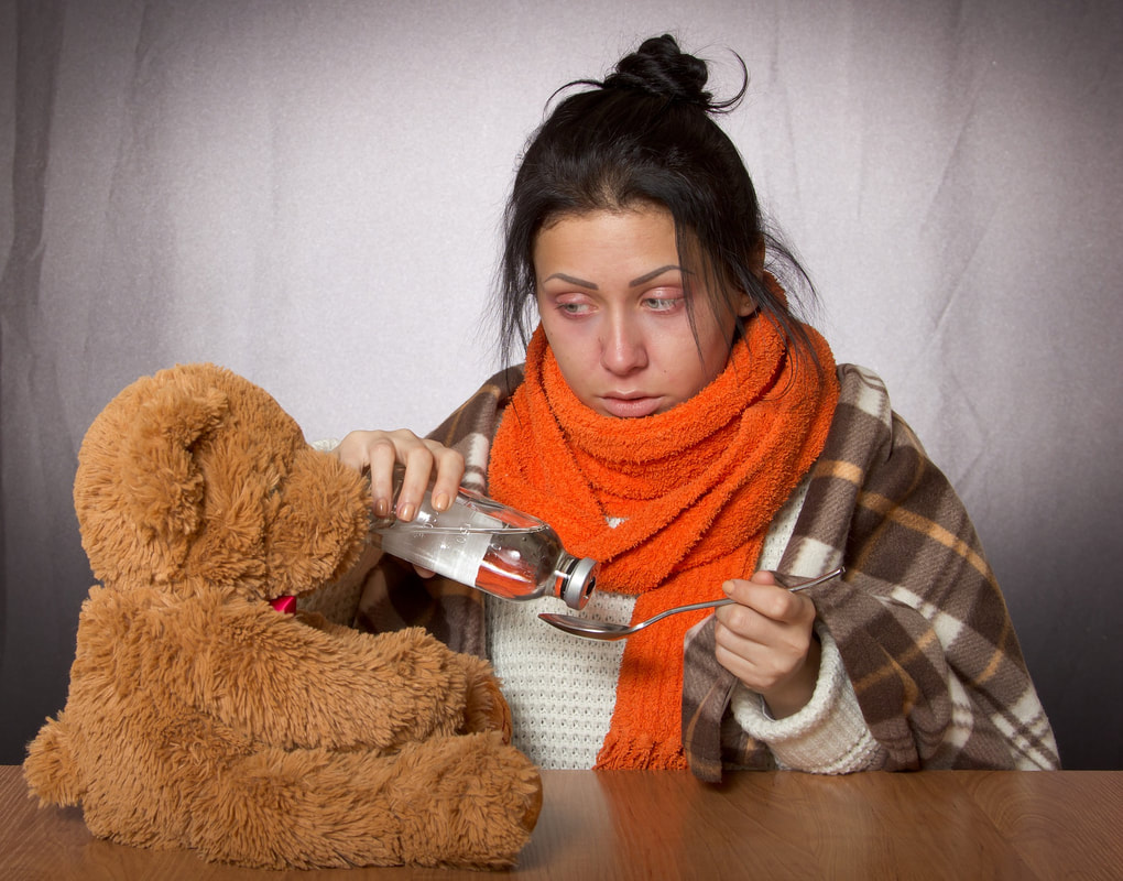 Sick woman with medicine and a teddy bear